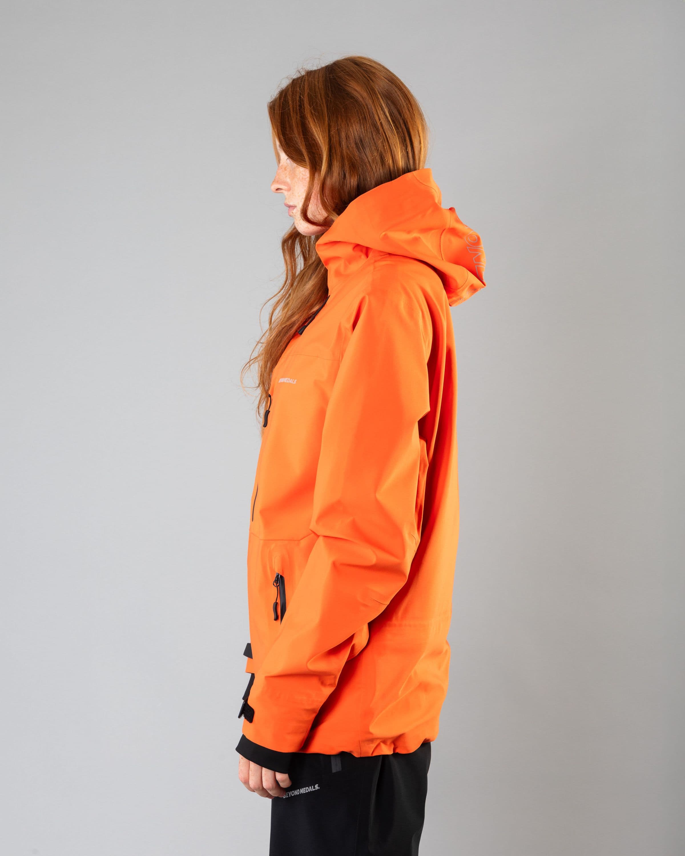 Outerwear clothing, pro tech jacket 3l in orange worn by model, Beyond Medals, 2024, side