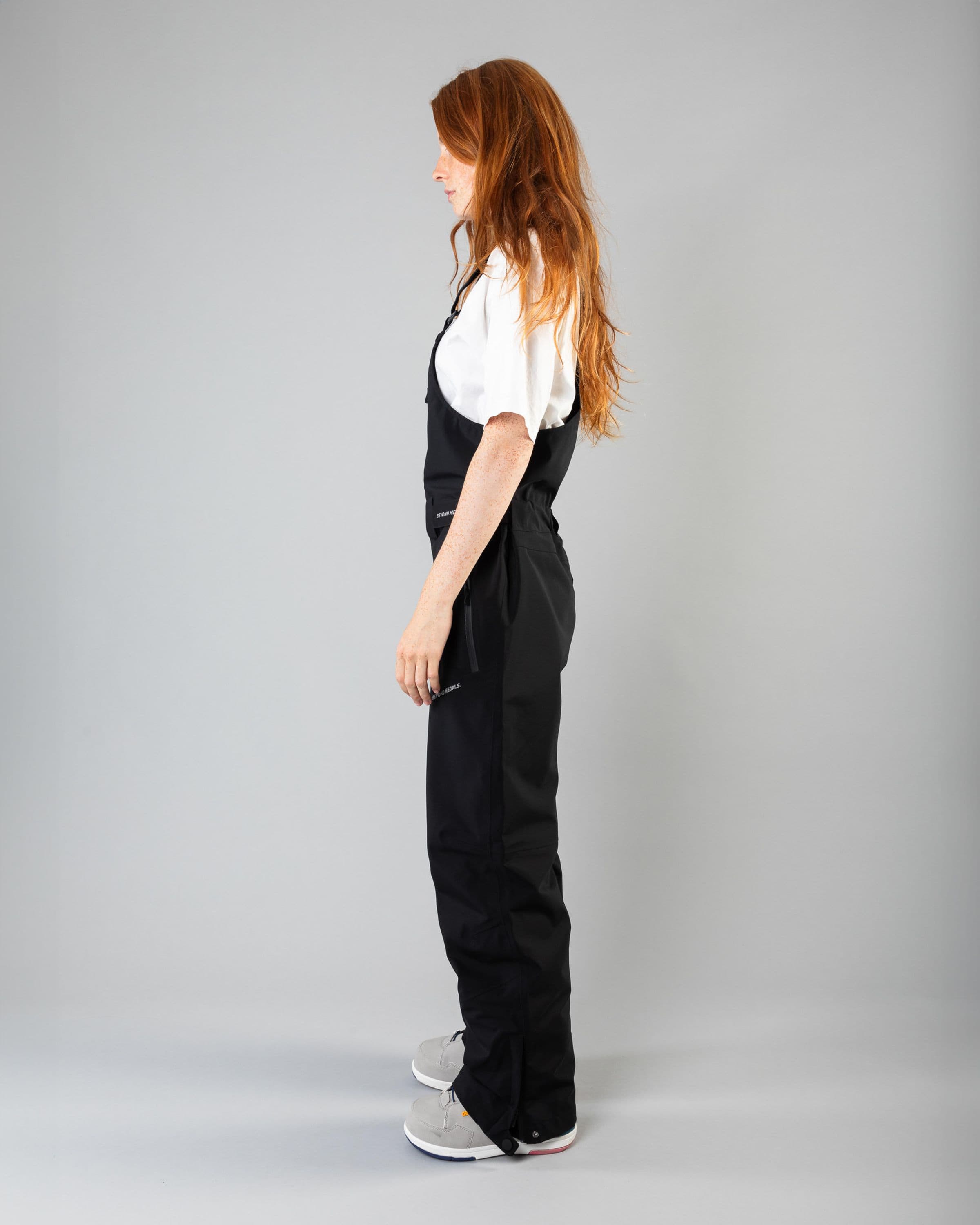 Outerwear clothing, tech bib 3l in black worn by model, Beyond Medals, 2024, side