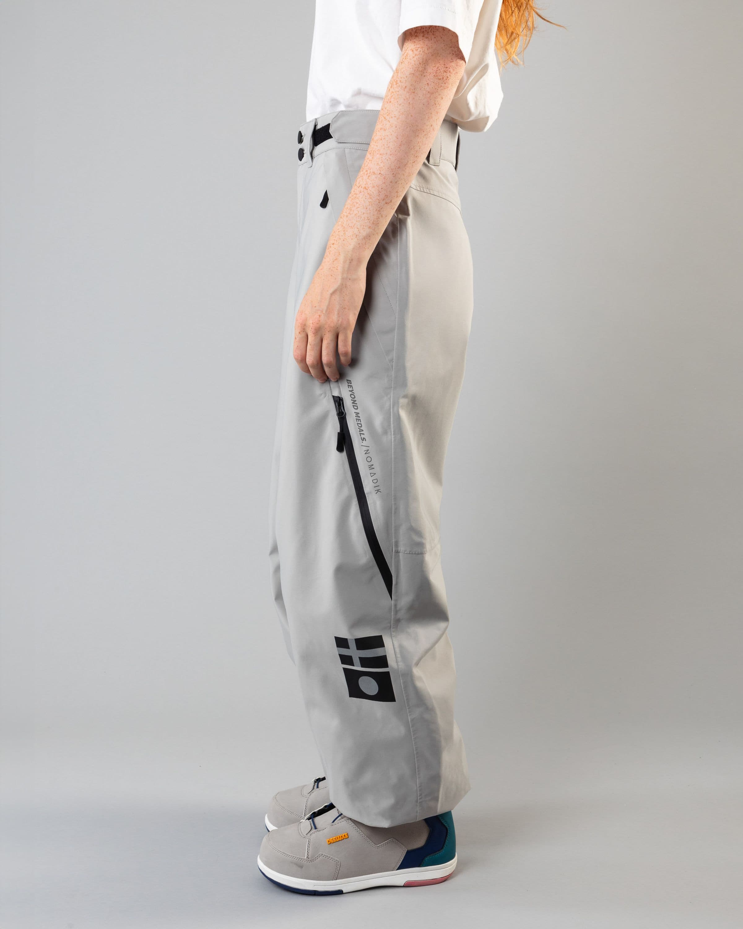 Outerwear clothing, beyond medals x nomadik pants 3l in grey worn by model, Beyond Medals, 2024, side
