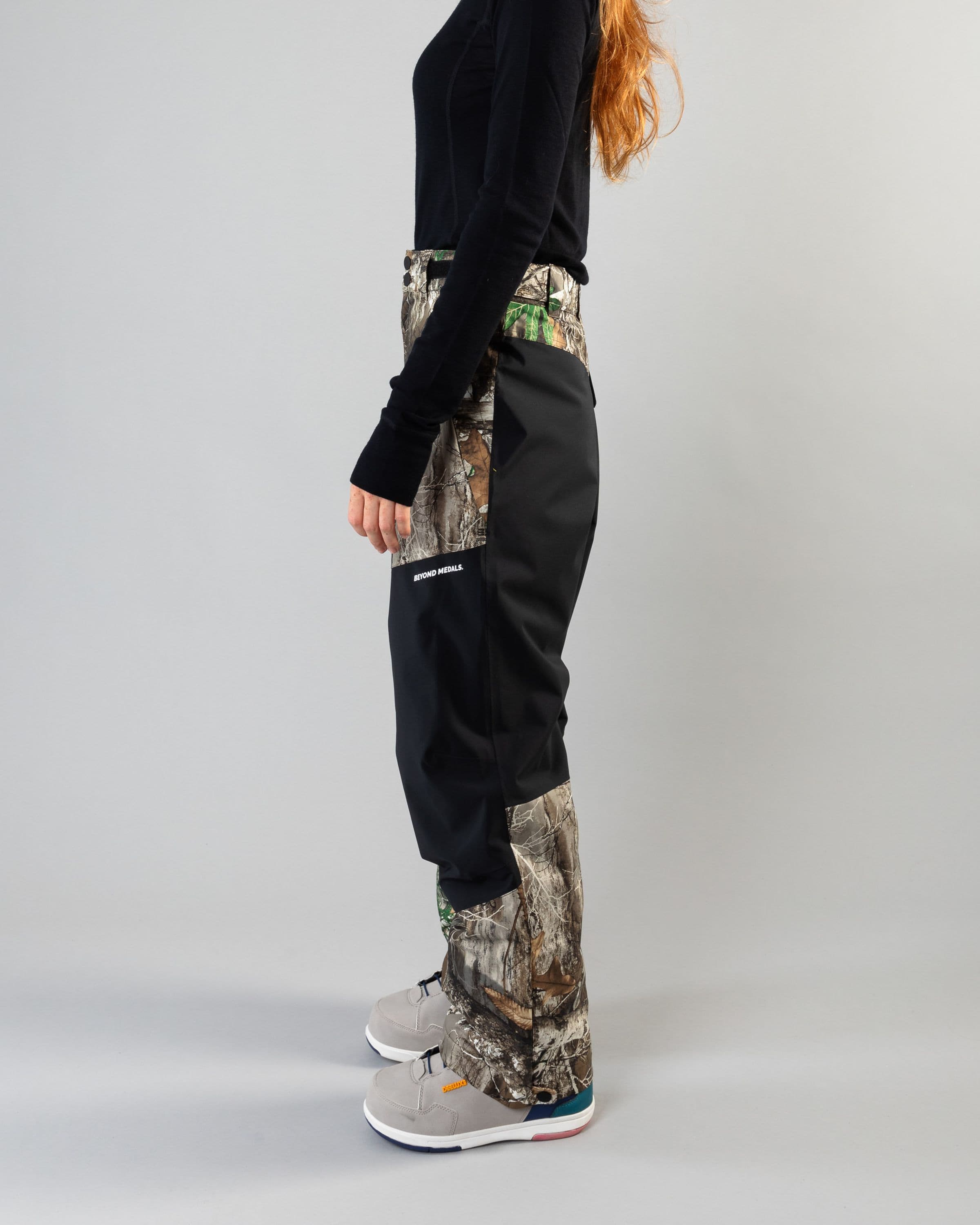 Outerwear clothing, zip pants 2l in realtree worn by model, Beyond Medals, 2024, side