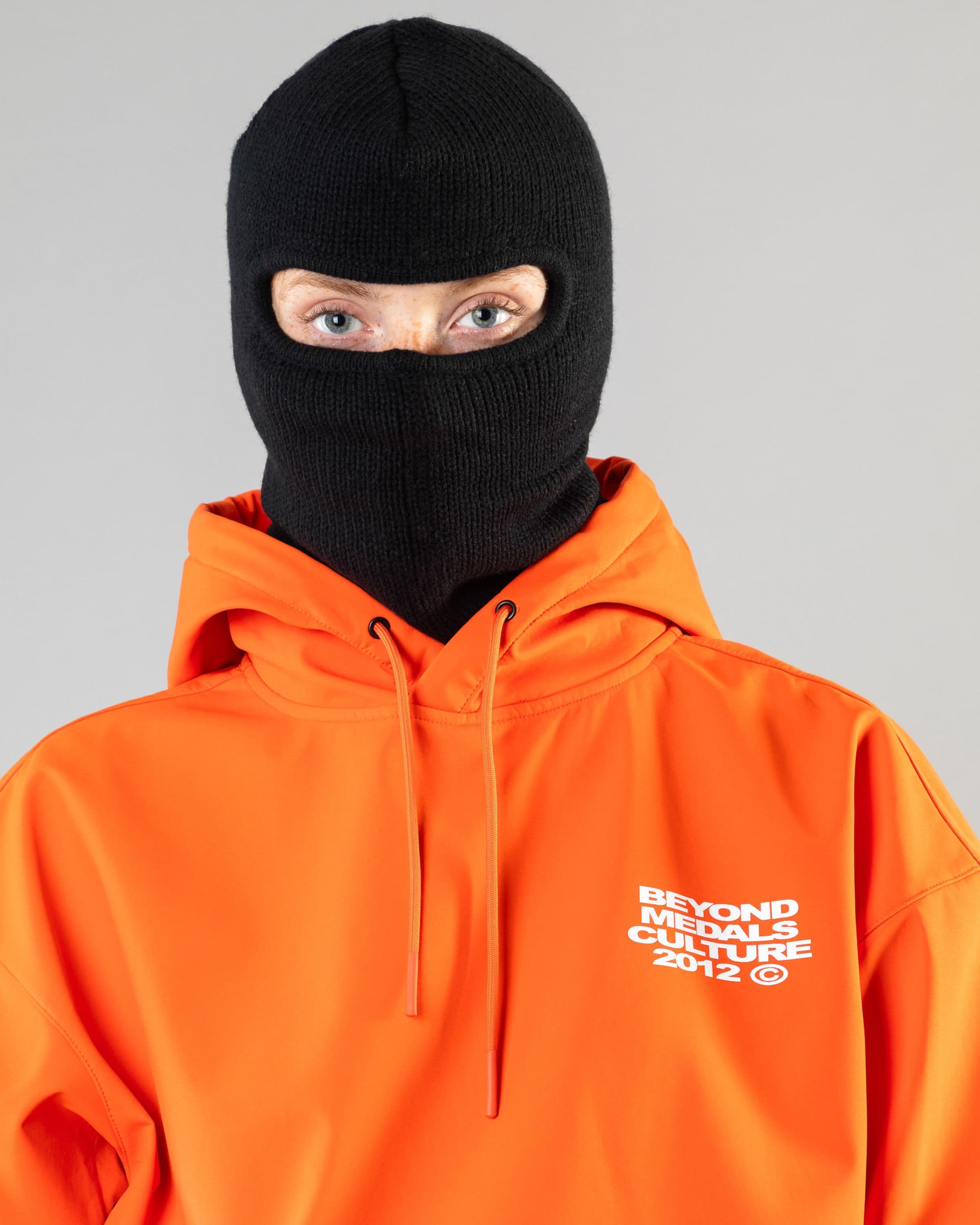 Outerwear clothing, softshell hoodie in orange worn by model, Beyond Medals, 2024, detail1