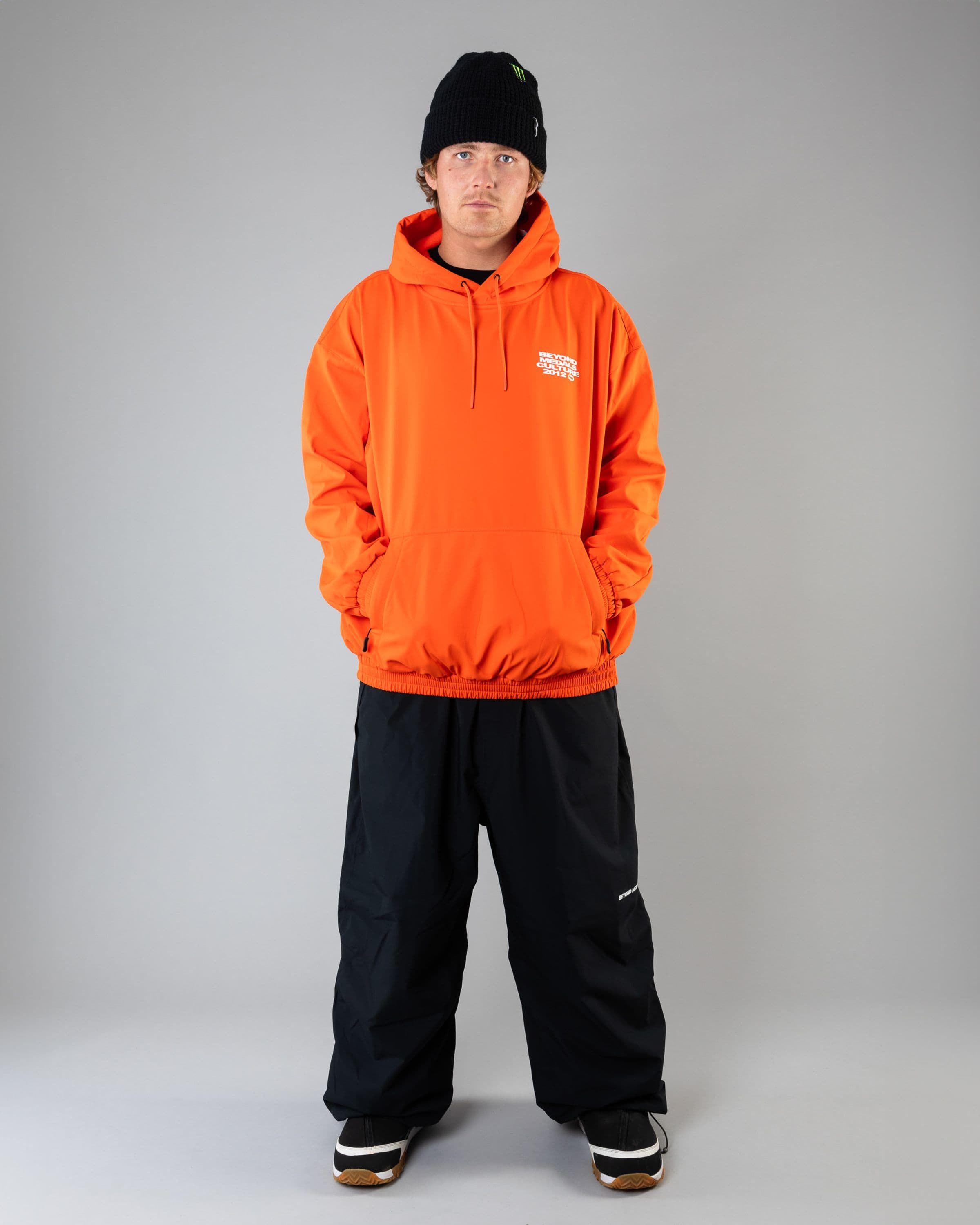 Outerwear clothing, softshell hoodie in orange worn by SEBBE DE BUCK, Beyond Medals, 2024, full front