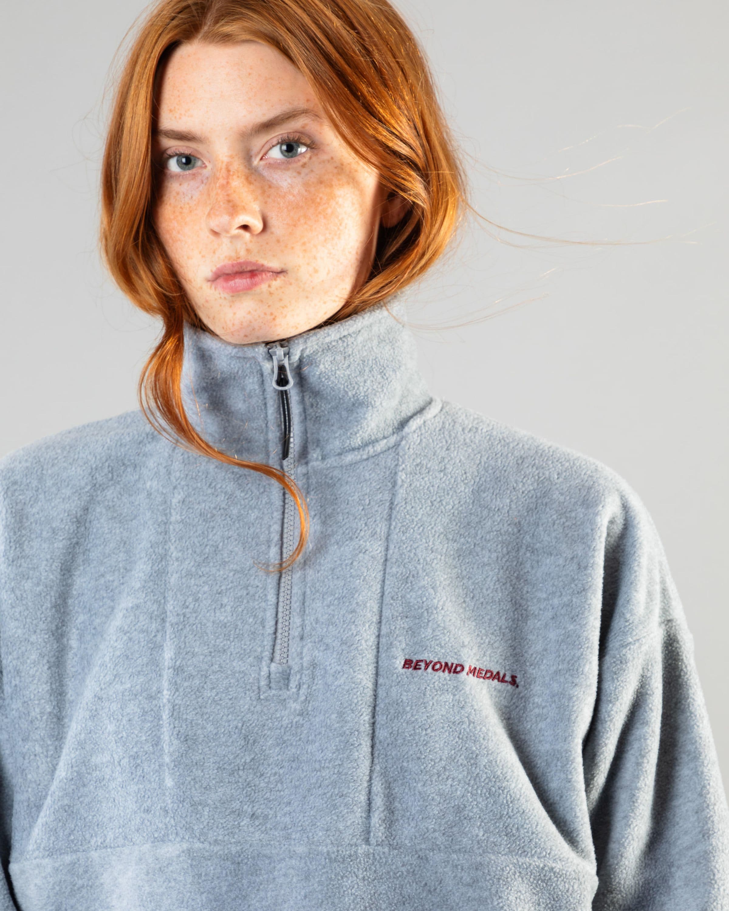 Streetwear clothing, halfzip fleece in grey worn by model, Beyond Medals, 2024, detail
