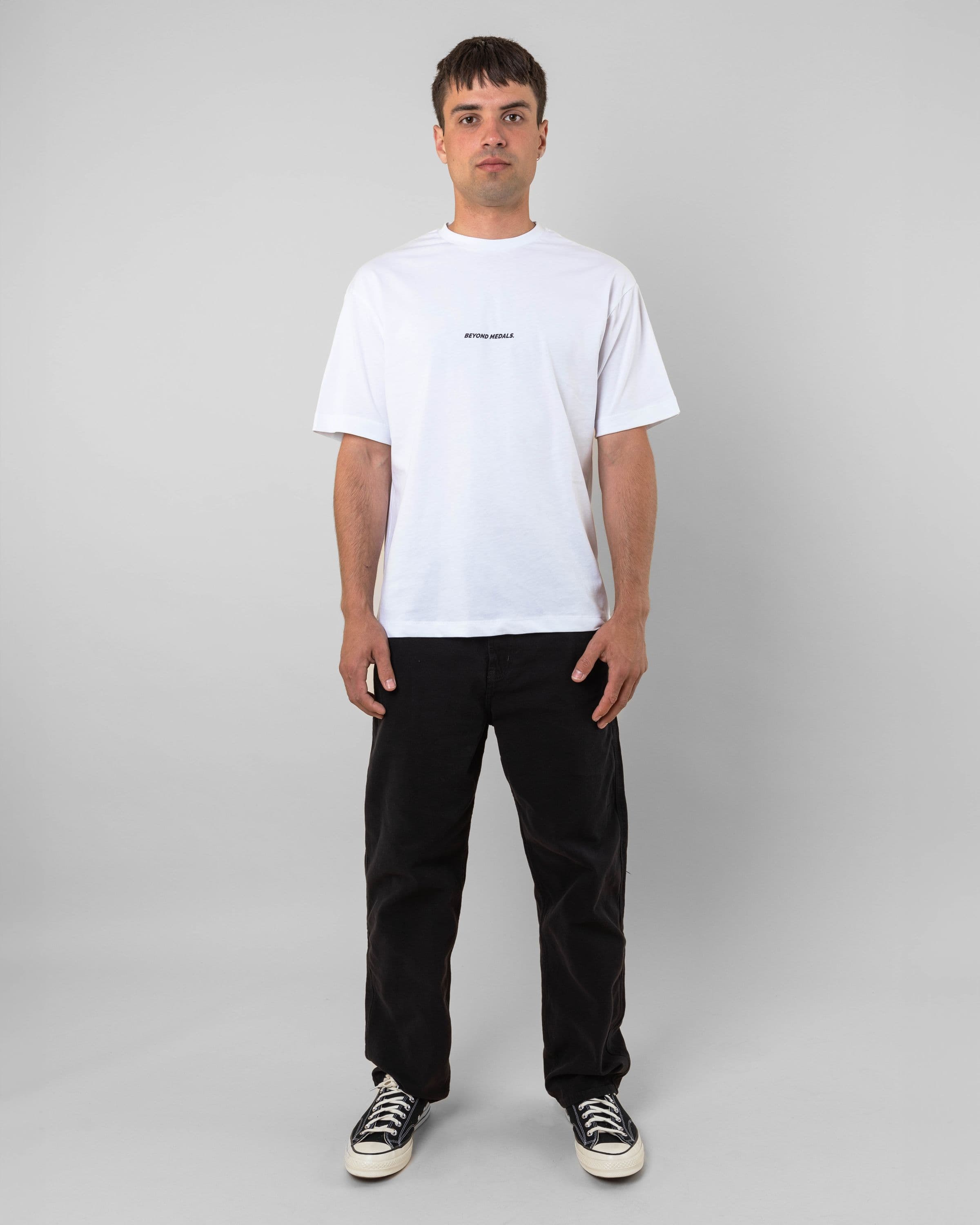 Streetwear clothing, baekkel tee in white worn by model, Beyond Medals, 2024 full front2