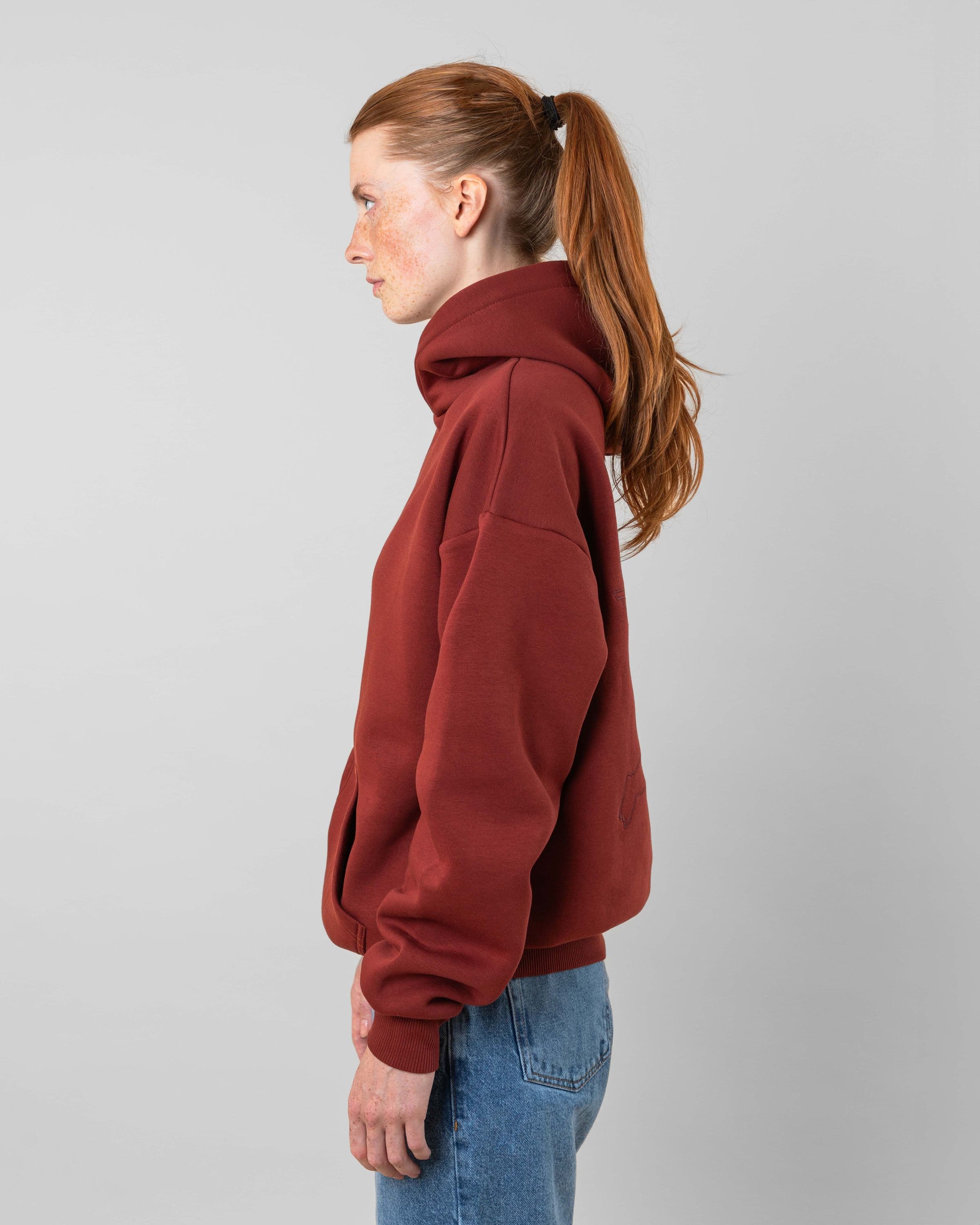 Streetwear clothing, angel hoodie 2.0 in red worn by model, Beyond Medals, 2024, side
