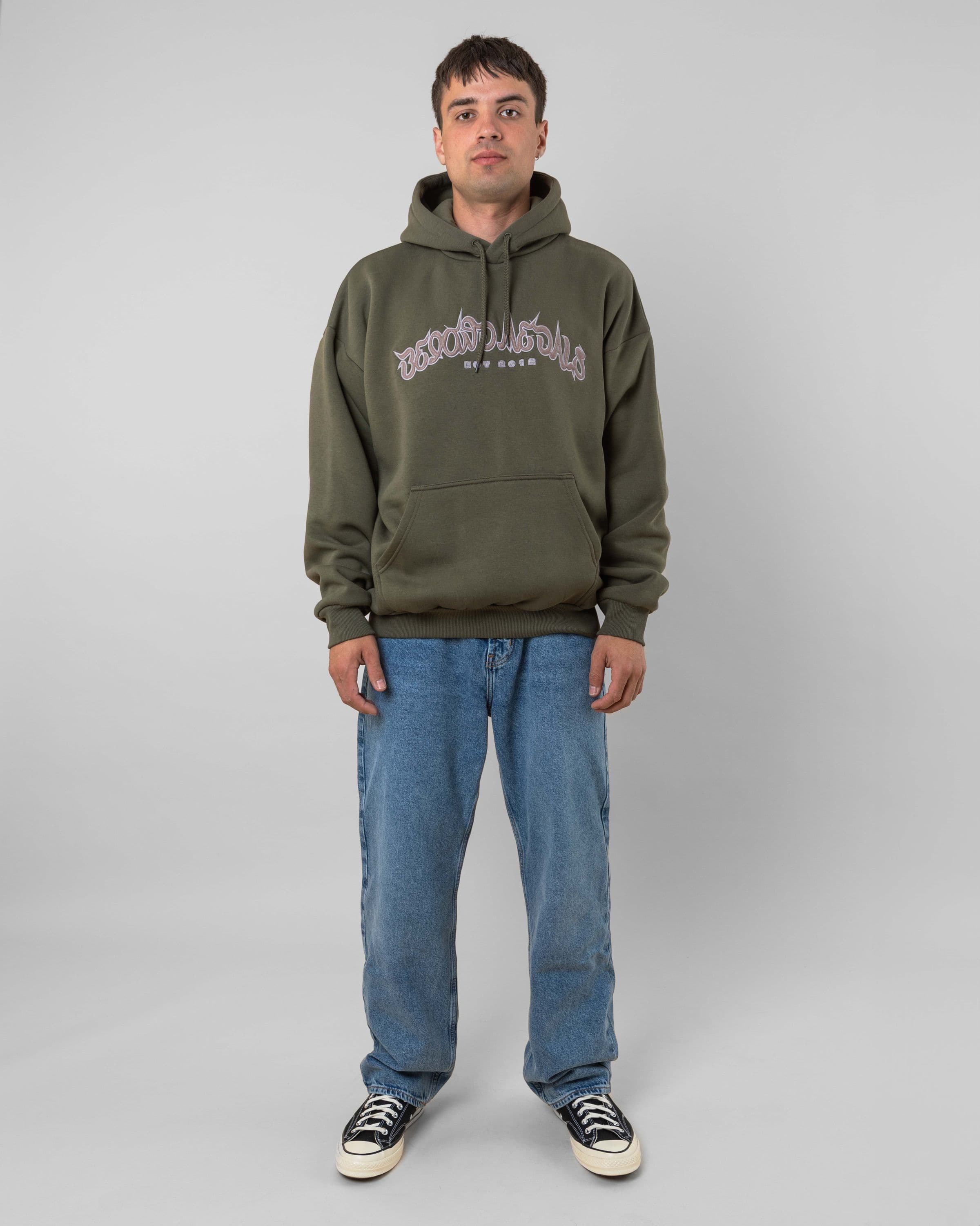 Streetwear clothing, 90s spike hoodie in green worn by model, Beyond Medals, 2024, full front1