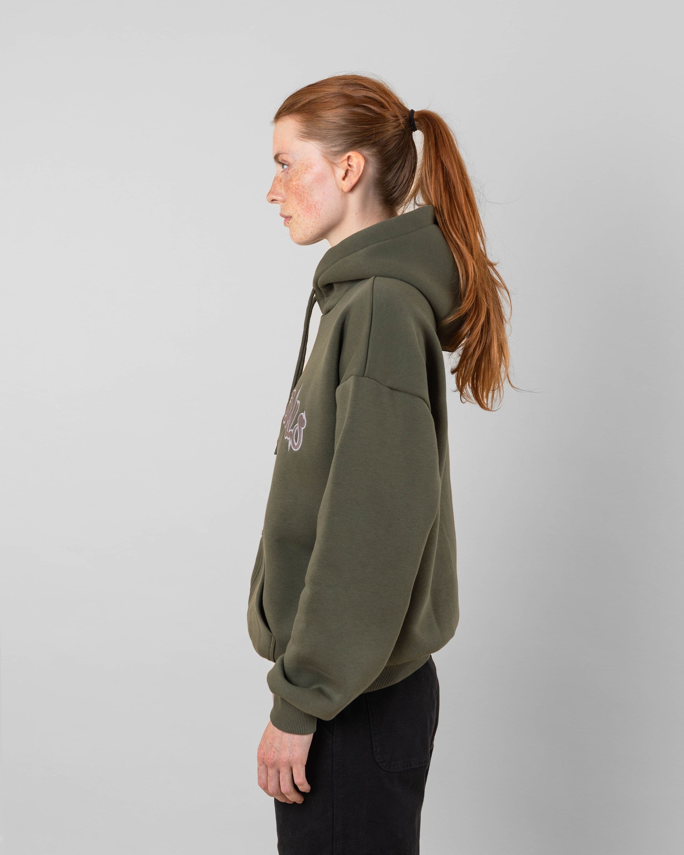 Streetwear clothing, 90s spike hoodie in green worn by model, Beyond Medals, 2024, side