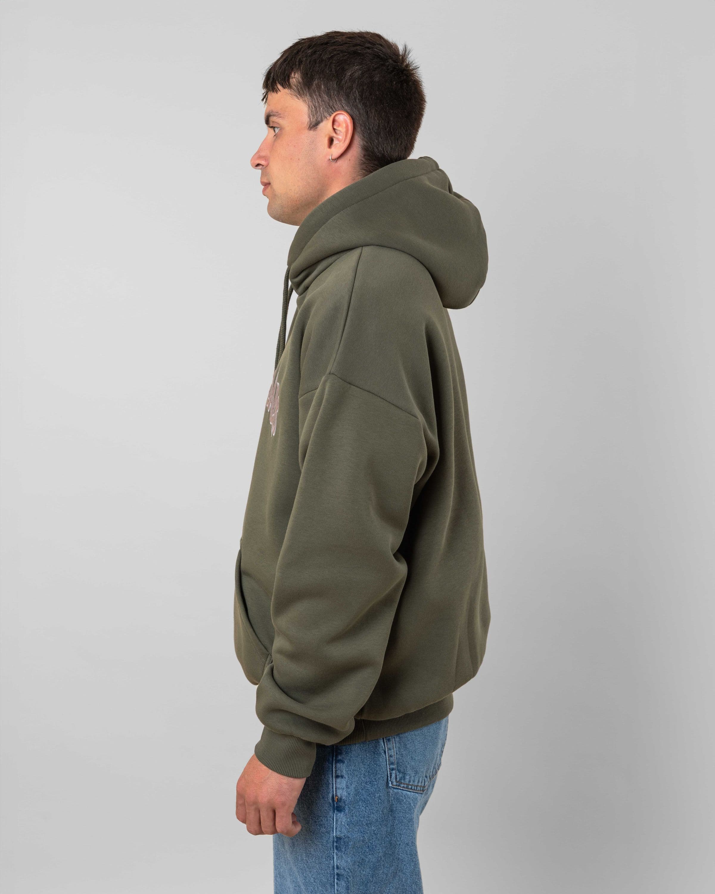 Streetwear clothing, 90s spike hoodie in green worn by model, Beyond Medals, 2024, side1