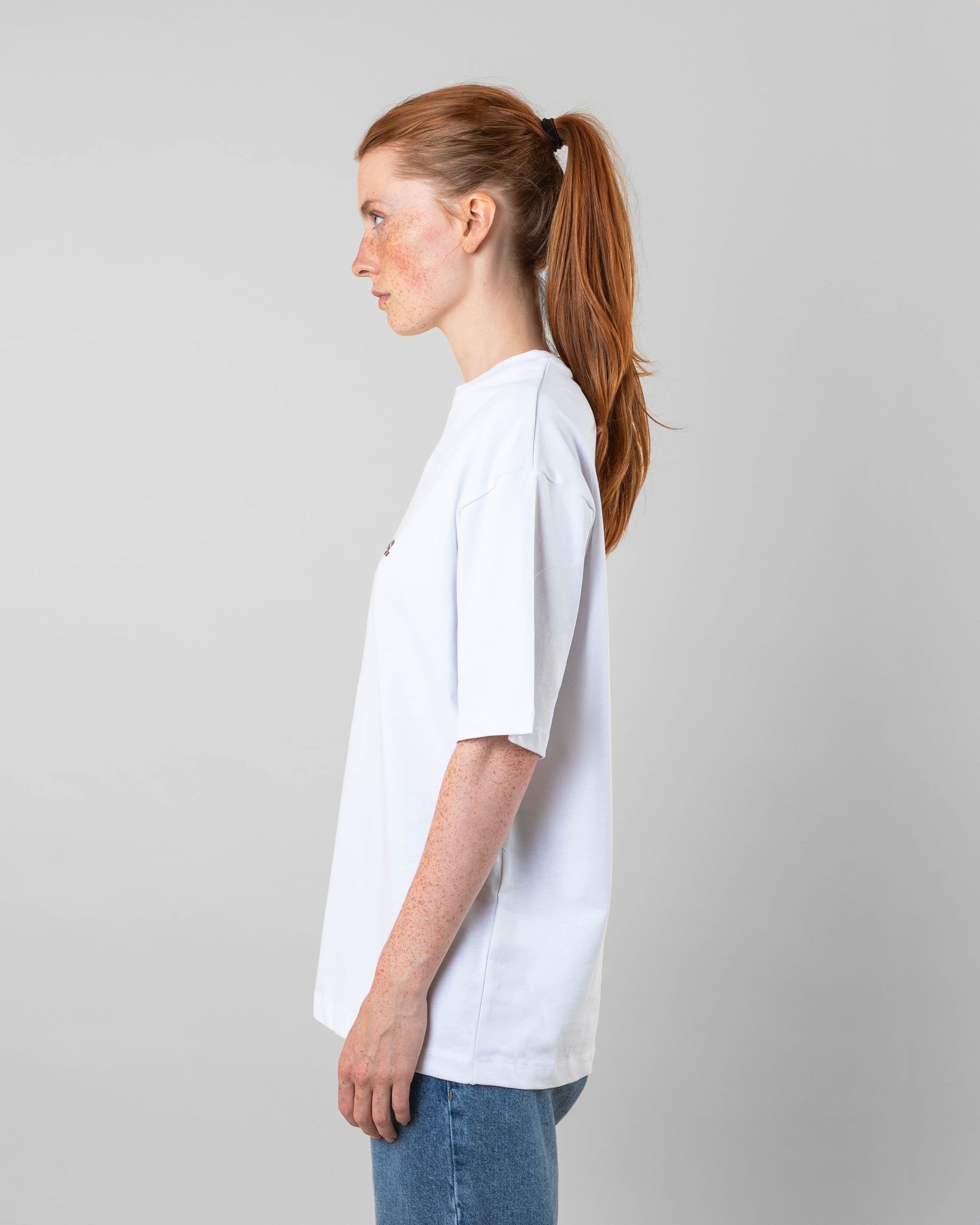 Streetwear clothing, medals tee in white worn by model, Beyond Medals, 2024, side